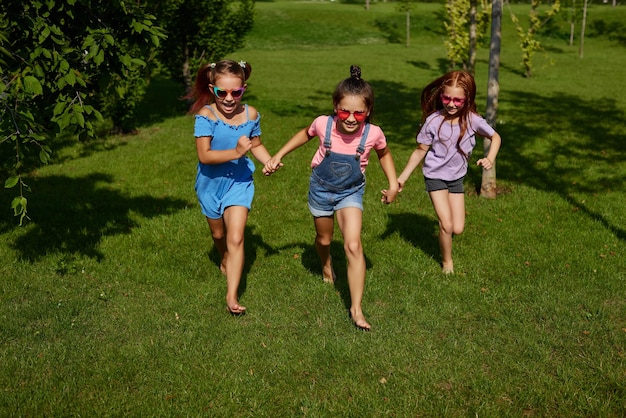 Niñas niños lindos felices corren en el parque