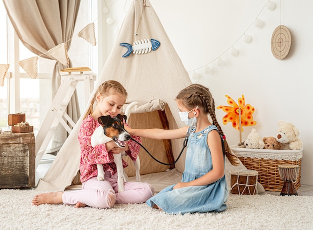 Niñas con perro escucha de fonendoscopio