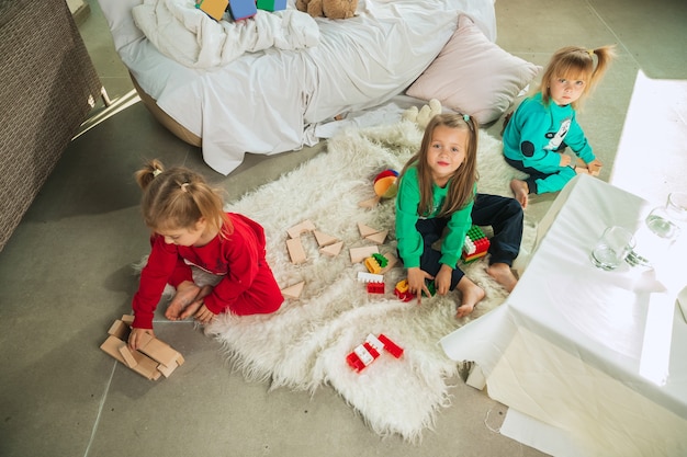 Niñas en pijama suave y cálido jugando en casa