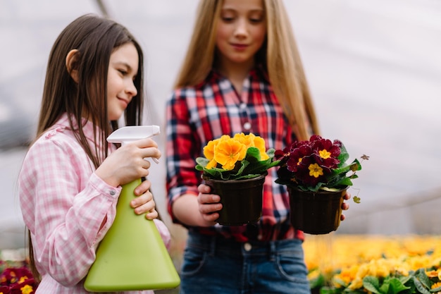 Niñas regando flores en el jardín