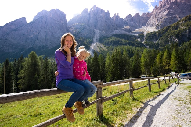 Foto niñas riendo hermanas excursionistas en las montañas dolomitas, italia. rifugio lunelli