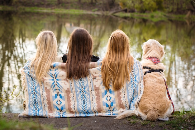 Las niñas se sientan a orillas del río.