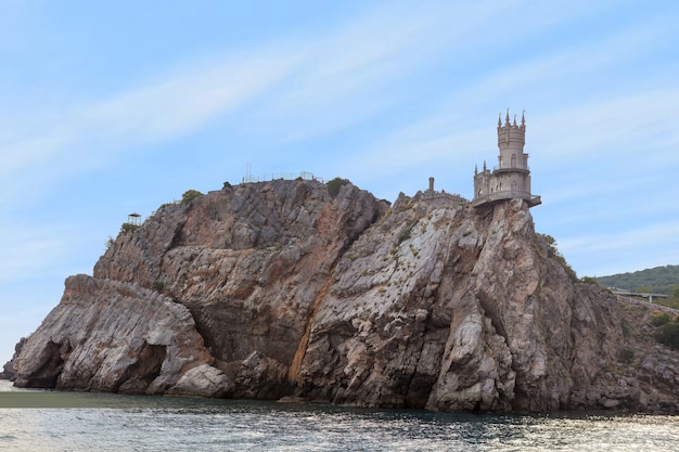 Ninho de andorinha do castelo medieval localizado no topo de um penhasco rochoso entre o Mar Negro. Famoso ponto turístico da velha torre na Crimeia, Rússia.