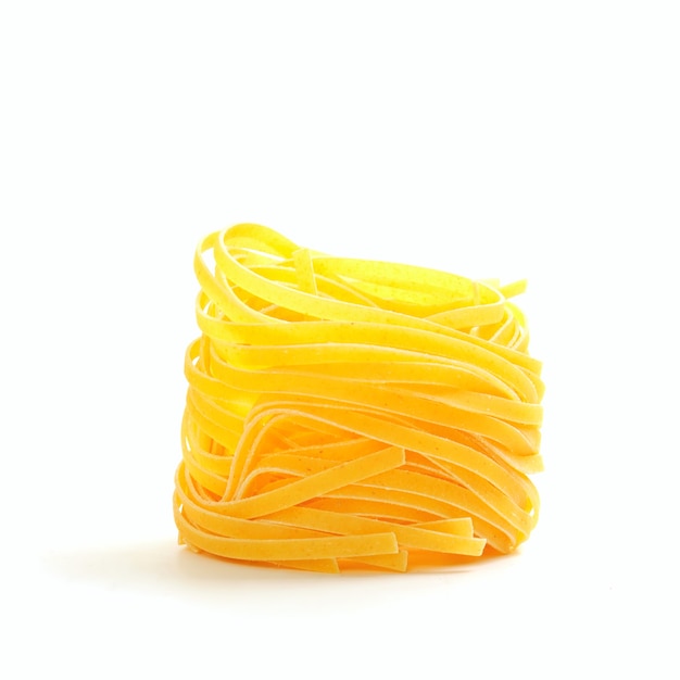 Foto ninho único de macarrão cru em uma tigela amarela isolado no branco
