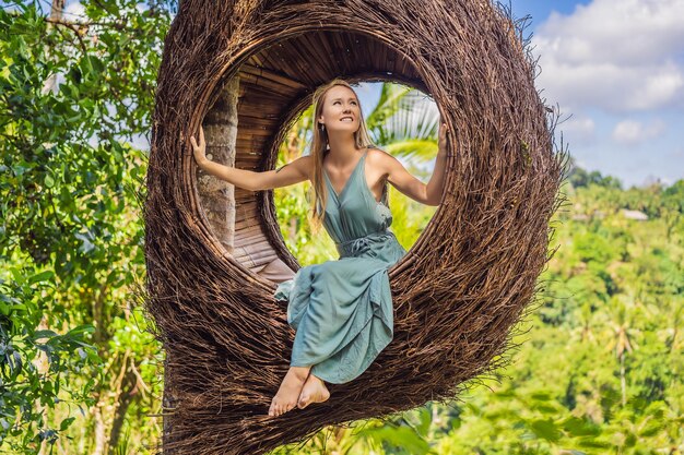 Ninhos de palha de tendência de Bali em todos os lugares Jovem turista curtindo sua viagem pela ilha de Bali Indonésia Fazendo uma parada em uma bela colina Foto em um ambiente natural de ninho de palha Estilo de vida