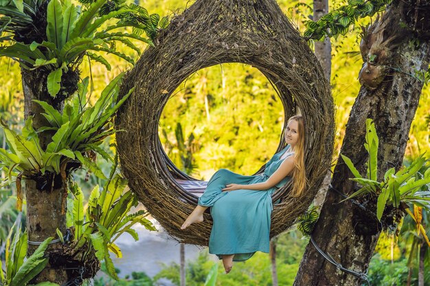 Ninhos de palha de tendência de Bali em todos os lugares Jovem turista curtindo sua viagem pela ilha de Bali Indonésia Fazendo uma parada em uma bela colina Foto em um ambiente natural de ninho de palha Estilo de vida