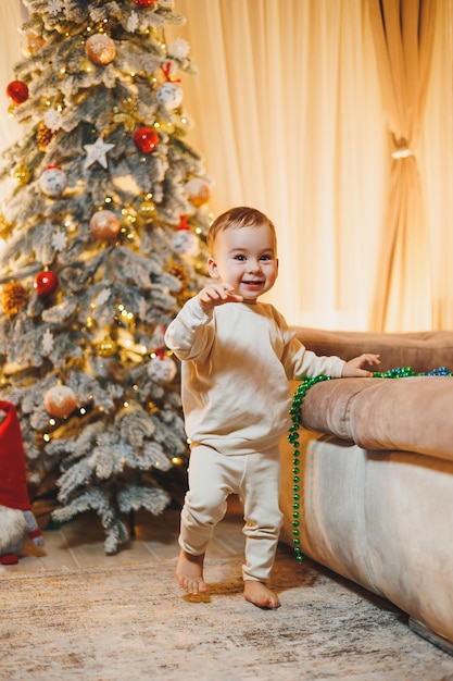 Un niño de 1 año decora el árbol de Navidad de Año Nuevo