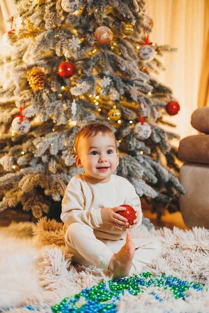 Un niño de 1 año decora el árbol de Navidad de Año Nuevo