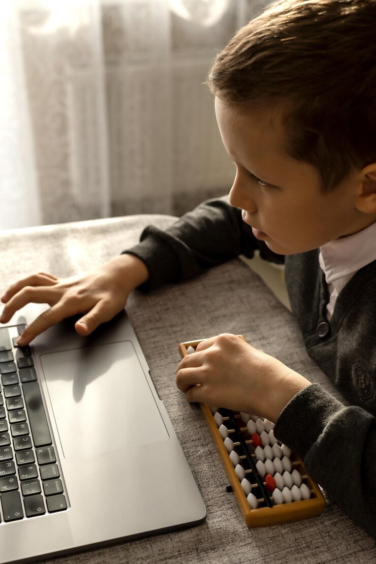 Foto un niño de 10 años aprende matemáticas mentales con una computadora portátil y un ábaco