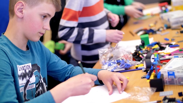 El niño de 12 años dibuja un dibujo un proyecto de un modelo de robot juega en el diseñador de cubos