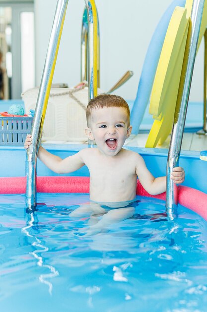 Un niño de 2 años aprende a nadar en una piscina limpia Desarrollo infantil Piscina de desarrollo para enseñar a los niños a nadar Escuela de natación