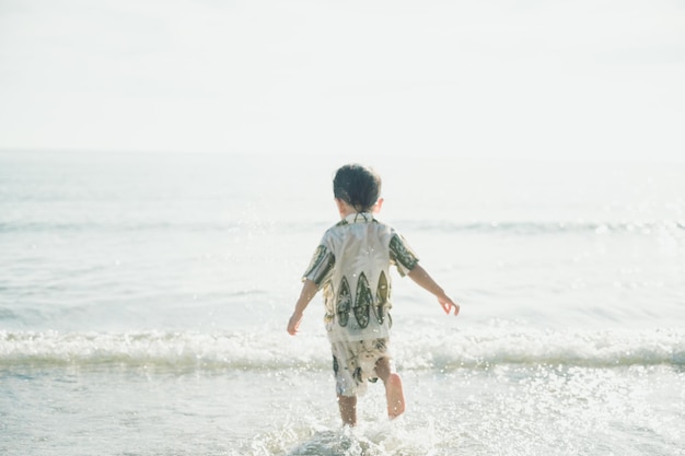 Foto niño de 2 años jugando arena en la playa, vacaciones con concepto de verano para bebés.