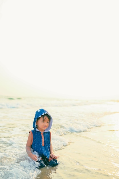 Foto niño de 2 años jugando arena en la playavacaciones con concepto de verano para bebés