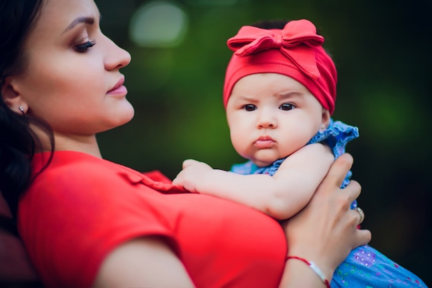 Niño de 3 meses en las manos de mamá al aire libre. Primer paseo para un recién nacido