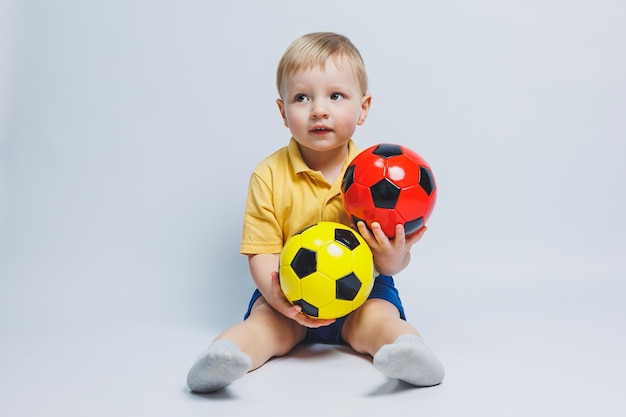 Niño de 34 años fanático del fútbol en una camiseta amarilla con una pelota en sus manos sosteniendo una pelota de fútbol en sus manos aislada en un fondo blanco El concepto de recreación familiar deportiva