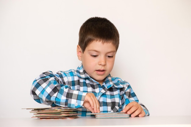 Un niño de 4 años juega con cartas con dibujos.