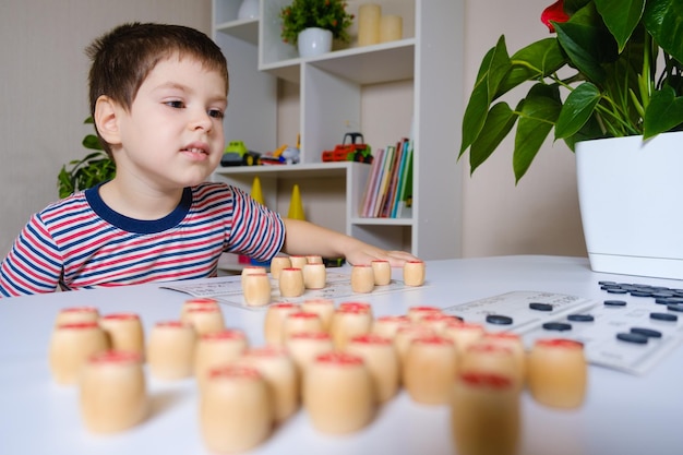 Un niño de 4 años juega números de estudios de loto usando un juego de mesa