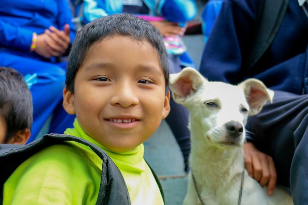 Niño de 6 años sonríe junto a su perro blanco