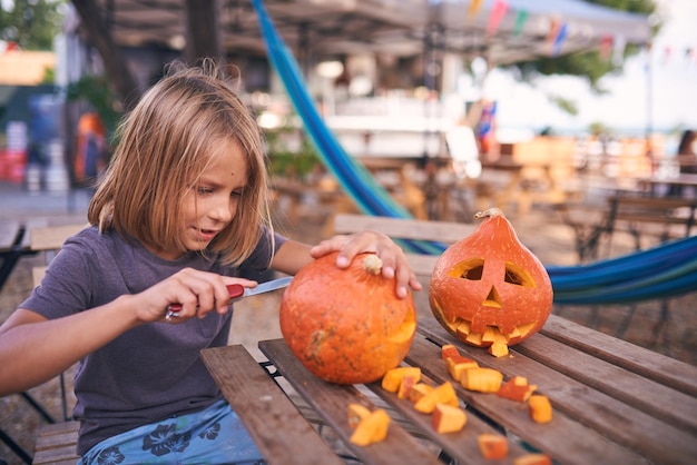 Niño de 8 años tallando calabaza de Halloween