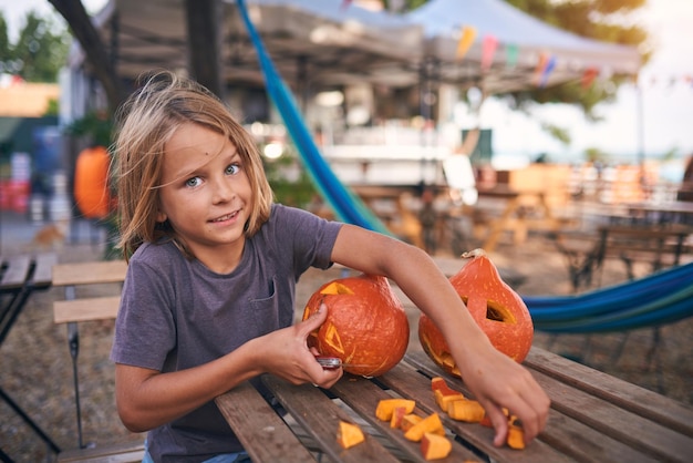 Niño de 8 años tallando calabaza de Halloween