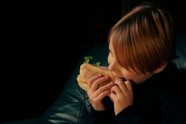 Niño de 9 años comiendo un sándwich de baguette grande