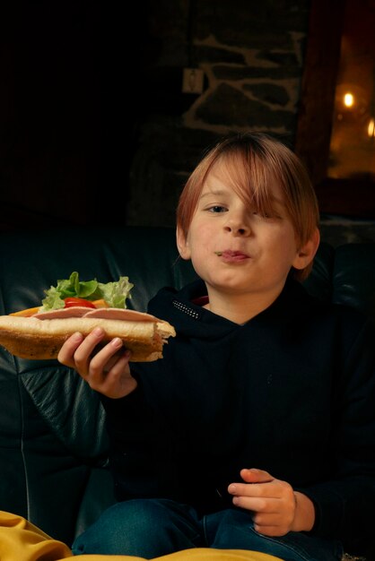 Niño de 9 años comiendo un sándwich de baguette grande