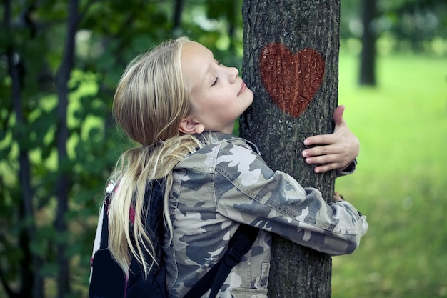 Niño abrazando árbol Protección del medio ambiente al aire libre Conservación de la naturaleza al aire libre