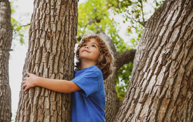 Foto niño abrazando una rama de árbol niño niño en una rama de árbol niño sube a un árbol