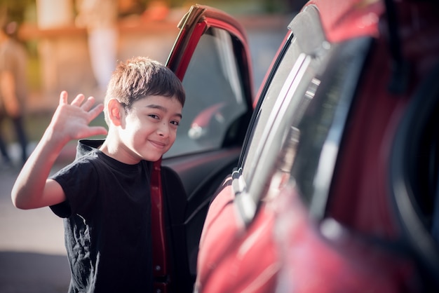 Niño abre la puerta del coche para entrar.