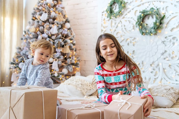 Niño abre regalos de Navidad bajo el árbol Enfoque selectivo