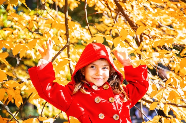 Niño en un abrigo rojo con hojas de otoño. Me encanta el otoño Enfoque selectivo