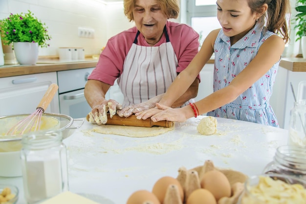 Niño y abuela en la cocina hornea prepara la masa en la cocina Enfoque selectivo Alimentos