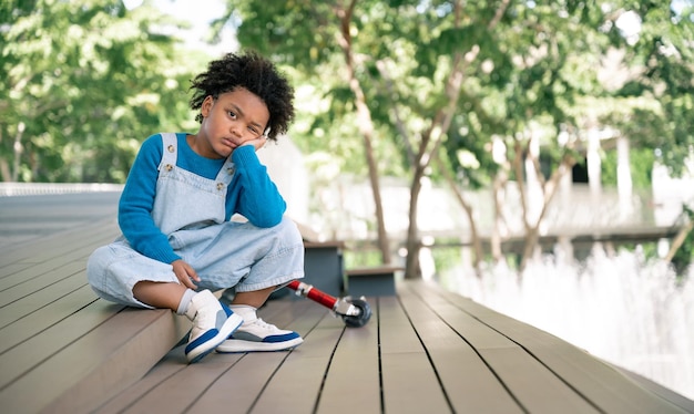 Niño aburrido con pelo afro en el parque