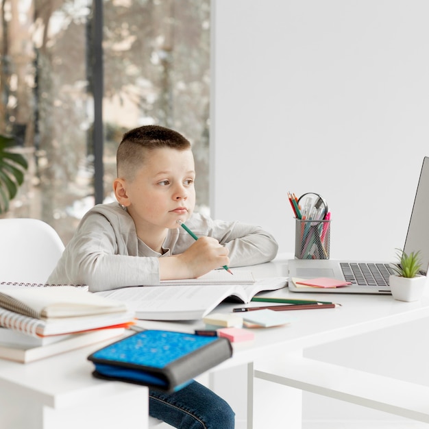 Foto niño aburrido que aprende cursos en línea