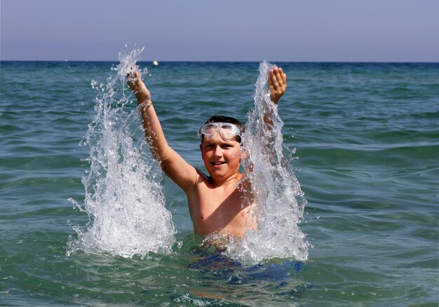 Niño activo jugando con agua de mar.