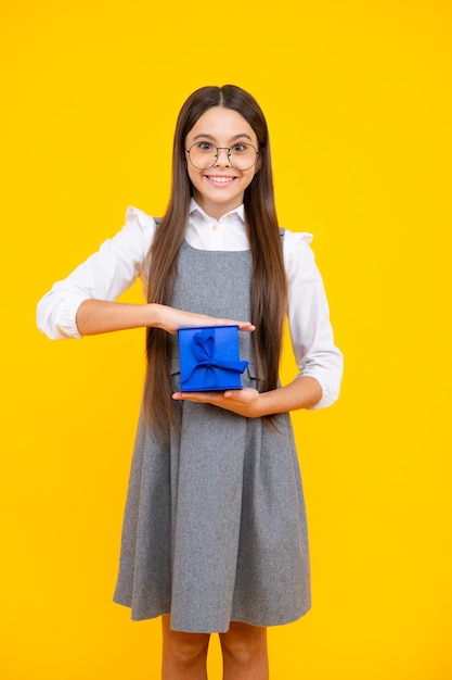 Niño adolescente con caja de regalo sobre fondo amarillo aislado Regalo para cumpleaños de niños Caja de regalo de Navidad o Año Nuevo