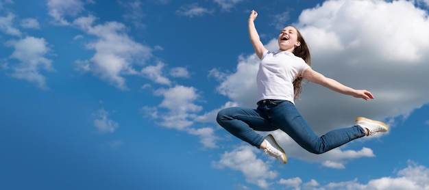 Niño adolescente feliz saltando sobre fondo de cielo Cartel horizontal de espacio de copia de encabezado de banner de cara de niño aislado