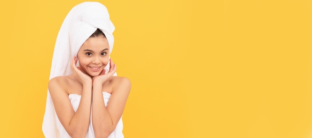 Niño adolescente feliz en toalla de ducha con crema en la cara Cosméticos y cuidado de la piel para diseño de póster de niño adolescente Banner de niña de belleza con espacio de copia