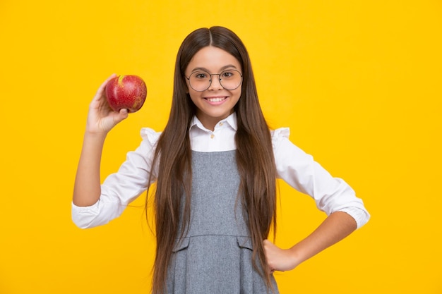 Niño adolescente con manzana sobre fondo amarillo aislado las manzanas son buenas para los niños Niña feliz se enfrenta a emociones positivas y sonrientes