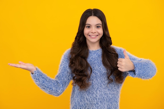 El niño adolescente positivo señala a un lado con expresión alegre muestra increíble en el espacio vacío en blanco Anuncio y maqueta Adolescente feliz emociones positivas y sonrientes de niña adolescente