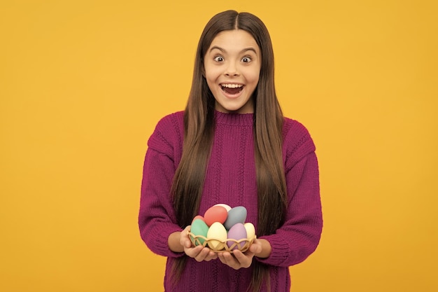 Niño adolescente sorprendido con huevos de codorniz pintados para la búsqueda de huevos de Pascua