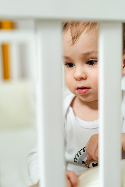 Niño adorable jugando en el dormitorio Niño pequeño jugando en la cama