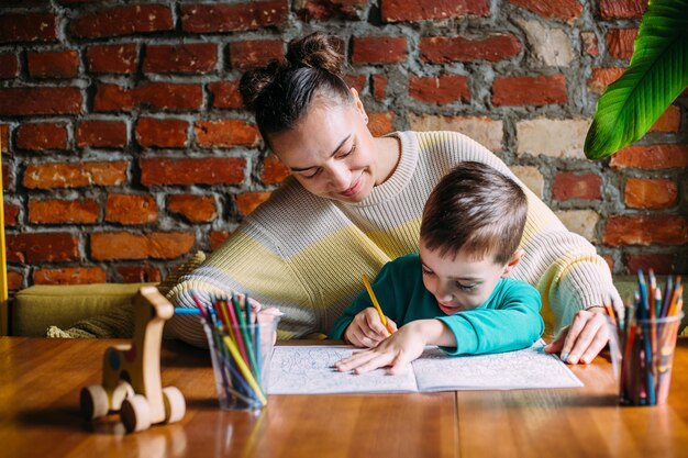 Niño y adulto están dibujando un libro para colorear