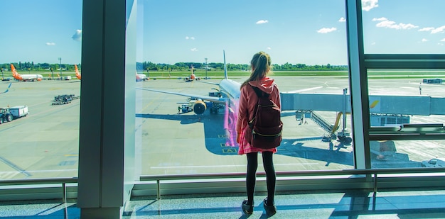 Un niño en el aeropuerto mira el avión. Enfoque selectivo. Niño.