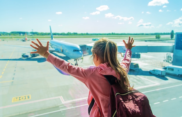 Un niño en el aeropuerto mira el avión. Enfoque selectivo. Niño.