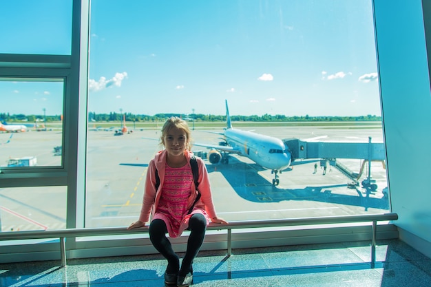 Un niño en el aeropuerto mira el avión. Enfoque selectivo. Niño.