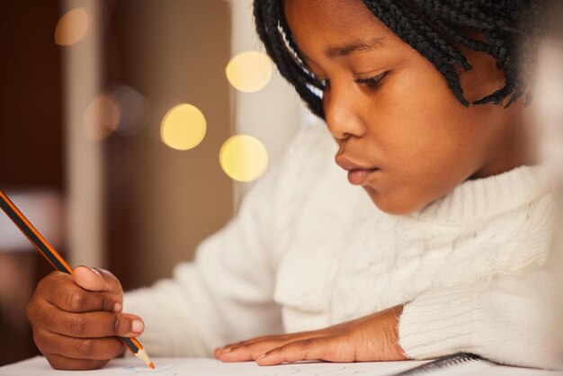 Niño africano dibujando y en casa con cuaderno crecimiento y desarrollo del niño artista y aprendizaje del arte educación creativa y niña en la casa mesa y lápiz con talento de color y juventud en el escritorio