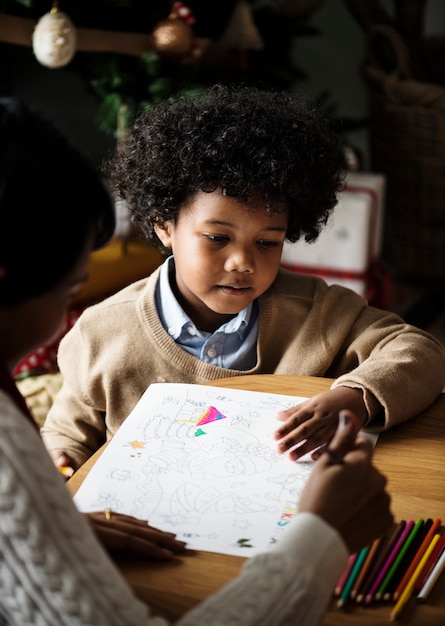 Niño africano disfrutando de un libro para colorear