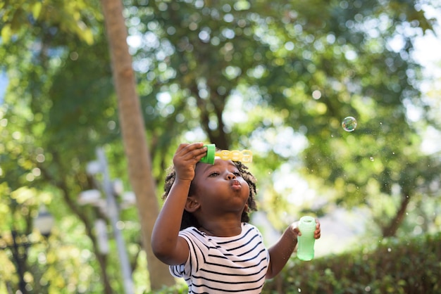 Niño africano jugando con burbujas