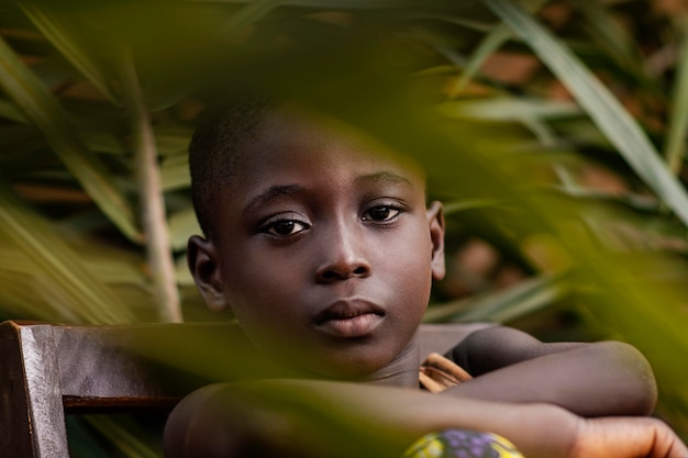 Foto niño africano de primer plano posando en silla